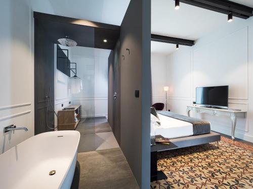 a bedroom with a bed and a bathroom with a tub at Habitat in Catania