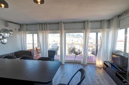 シッチェスにあるChic Sea View Apartment by Hello Homes Sitgesのリビングルーム(テーブル、大きな窓付)