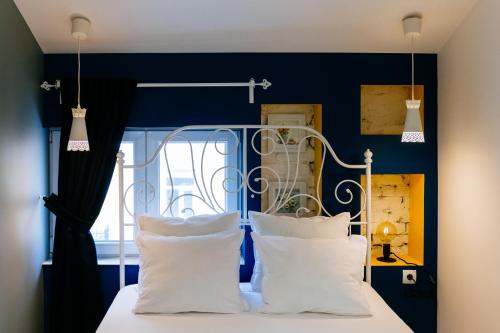 a bedroom with blue walls and a bed with white pillows at Beautiful best location apartment "Blue Mouse" in Plovdiv