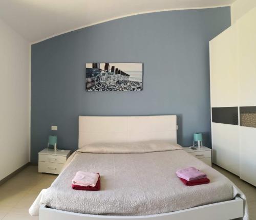Un dormitorio con una cama grande con toallas rosas. en Villa Carrubbedda, en Giba