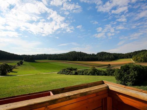 vistas a un campo verde con una valla de madera en Ferienwohnung Hutzler en Pottenstein