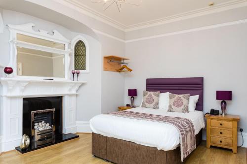 a bedroom with a bed and a fireplace at The Lawn Guest House Gatwick in Horley