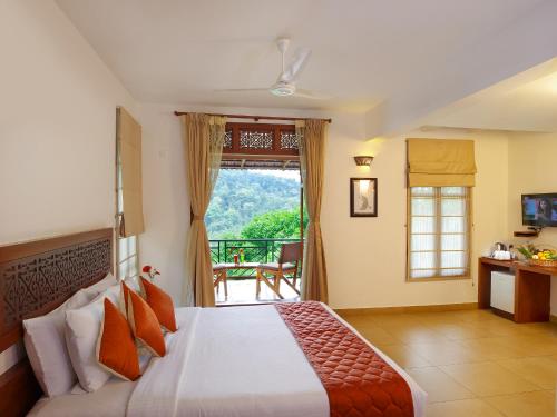 ein Schlafzimmer mit einem großen Bett und einem Balkon in der Unterkunft Forest Canopy Thekkady in Thekkady