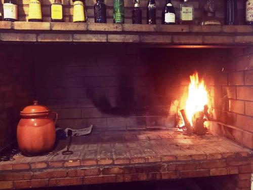 a brick oven with a pot and a fire at Hostal Restaurante Ego's in Campo de Criptana