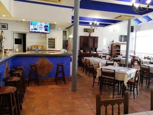 a restaurant with tables and chairs and a bar at Hostal Restaurante Ego's in Campo de Criptana