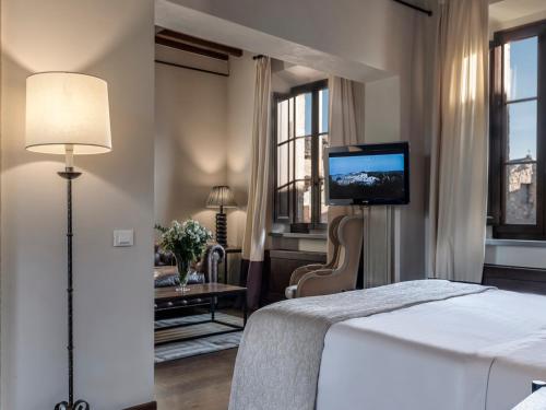 a hotel room with a television and a bed at Castel Monastero - The Leading Hotels of the World in Castelnuovo Berardenga