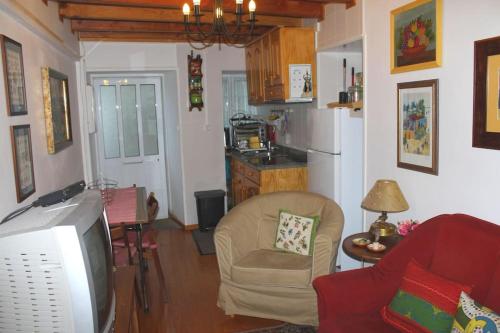 a living room with a tv and a kitchen at Doce Lar in Manteigas