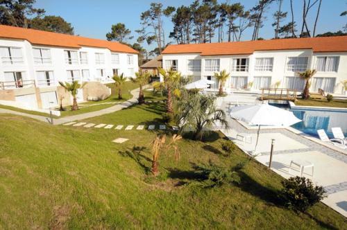 a hotel with a swimming pool and a resort at Punta del Este Arenas Hotel in Punta del Este
