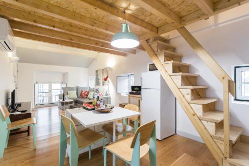 a kitchen and living room with a staircase and a table and chairs at Apartments Center Bairro Alto in Lisbon