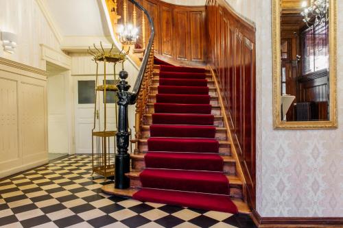a staircase with red carpeting and a red rug at Hotel & Restaurant "Deutscher Kaiser" in Perleberg