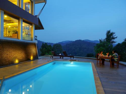 a swimming pool in front of a house at Forest Canopy Thekkady in Thekkady