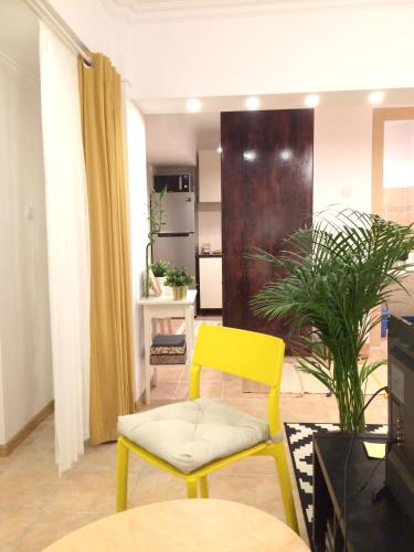 a living room with a yellow chair and a table at My Little Studio in Bucharest
