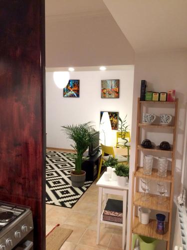 a living room with a table and some plants at My Little Studio in Bucharest
