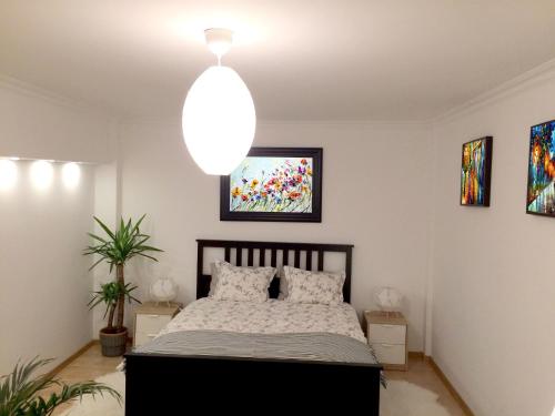 a bedroom with a bed and a hanging light at My Little Studio in Bucharest
