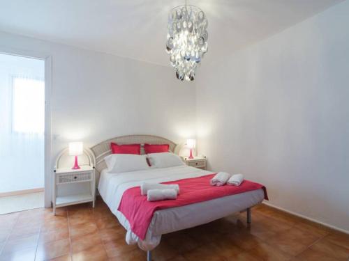 a bedroom with a bed with red pillows and a chandelier at Larios penthouse with terrace and 2 bedrooms in Málaga