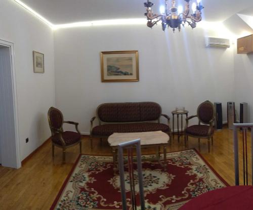 a living room with chairs and a table and a chandelier at Resident hill resort in Belgrade