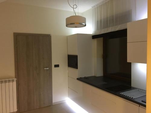 kuchnia z białymi szafkami i czarnym blatem w obiekcie Silver Residence w Rabce