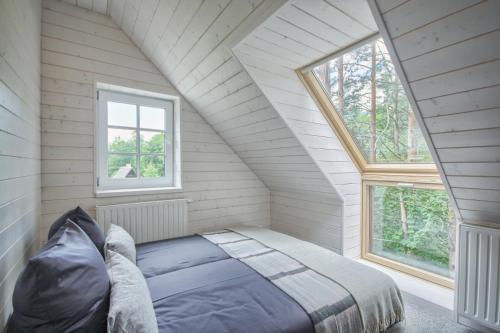 une chambre avec un lit et deux fenêtres dans l'établissement Villa Rata, à Ratnyčia