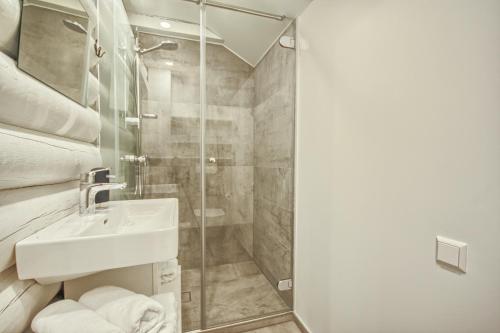 une salle de bain avec lavabo et douche dans l'établissement Villa Rata, à Ratnyčia