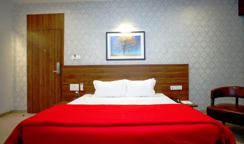 a bedroom with a red bed with a red blanket at Mastiff Hotel Chinchwad by OTHPL in Pune