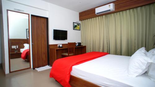 a hotel room with a bed and a television at Mastiff Hotel Chinchwad by OTHPL in Pune