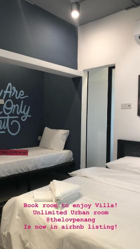 a bedroom with two beds and a wall with a sign on it at The Best Hotel in Bayan Lepas - THE LOV PENANG in Bayan Lepas