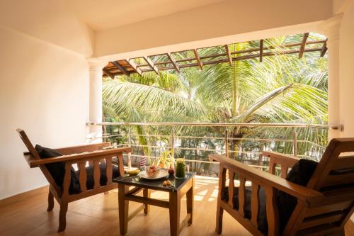 a room with chairs and a table and a large window at Crystall Goa Emerald Edition in Patnem