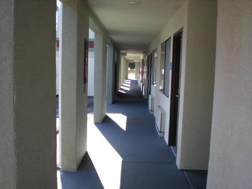 an empty hallway of a building with the sun shining down at The Redwood Riverwalk, a boutique hotel in Fortuna