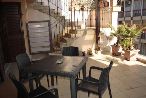 d'une table et de chaises sur un balcon avec un escalier. dans l'établissement Casa-B&B Bouganville Attico 85 mq, à Barletta