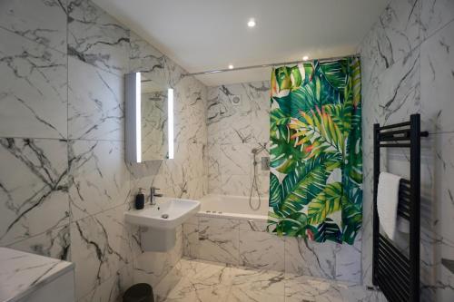 a bathroom with a sink and a shower curtain at N5 Townhouse, Brighton Sleeps 20 in Brighton & Hove