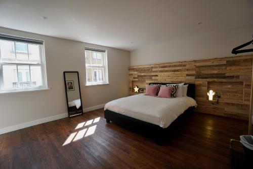 a bedroom with a large bed and two windows at N5 Townhouse, Brighton Sleeps 20 in Brighton & Hove