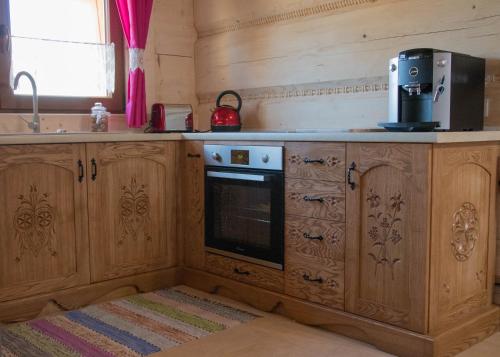a kitchen with wooden cabinets and a stove top oven at Dwór Pan Tadeusz in Orawka