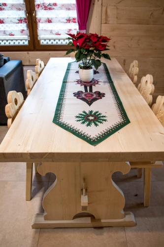 a wooden table with a vase of flowers on it at Dwór Pan Tadeusz in Orawka