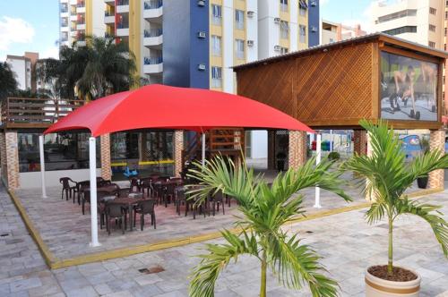 un ombrellone rosso di fronte a un ristorante con tavoli e sedie di Eldorado Park Caldas Novas a Caldas Novas