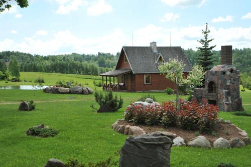 a house in the middle of a field with a garden at Country Houses Vidų Sodyba in Utena