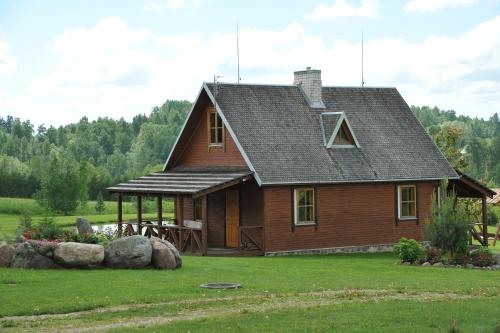 a log cabin with a gambrel roof at Country Houses Vidų Sodyba in Utena