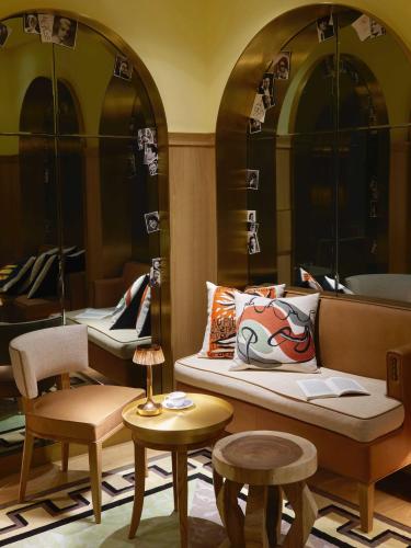 a room with a couch and chairs and tables at 9Confidentiel in Paris