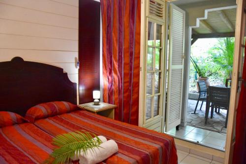 1 dormitorio con 1 cama y puerta que da a un patio en Résidence Turquoise Guadeloupe - Vue mer et lagon, en Le Gosier