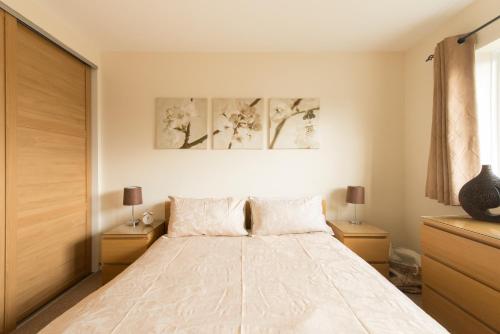 una camera da letto con un letto grande con due comodini di Chesterton Court Apartment a Gloucester