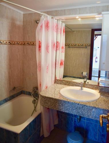 a bathroom with a tub and a sink and a bath tub at Villa Koki Studios in Lindos