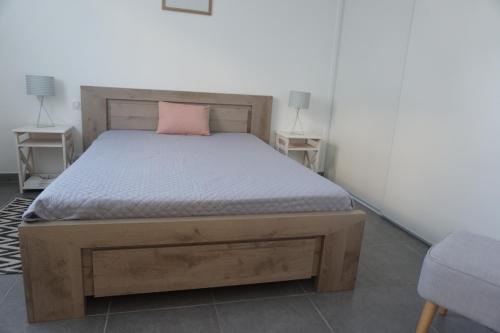 ビスカロッスにあるB13 RÉSIDENCE LE PALOMBAGGIA -064のベッドルーム1室(ピンクの枕と木製ベッド1台付)