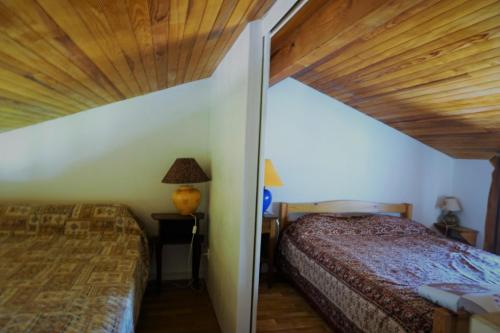 ビスカロッスにある16 RÉSIDENCE LA DUNE OCÉANE 1 -070の木製の天井が特徴のベッドルーム1室(ベッド2台付)
