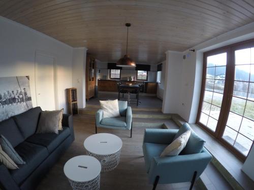 a living room with a couch and chairs and a table at Haus Pistenblick in Russbach am Pass Gschütt