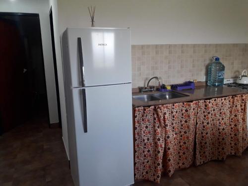 una nevera blanca en una cocina con fregadero en Departamento Estancia Vieja 74 PB en Estancia Vieja
