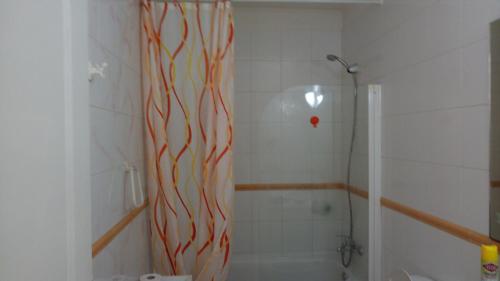 アデへにあるMareverde relaxのバスルーム(赤い渦巻きシャワーカーテン付きのシャワー付)