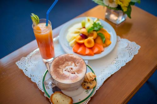 einen Tisch mit einem Getränk und einem Teller Essen in der Unterkunft Hôtel Colbert - Spa & Casino in Antananarivo