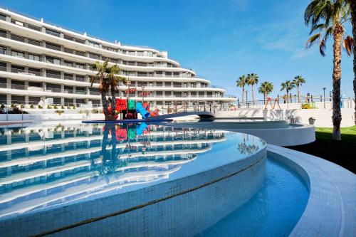 um grande edifício com uma piscina ao lado de uma praia em Dream Infinity View Apartment em Arenales del Sol