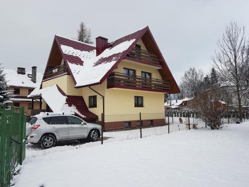 ザコパネにあるU Kasprówの雪に覆われた家の前に停められた車