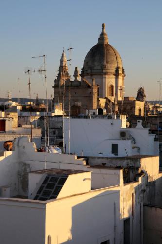 a view of roofs of buildings with a cathedral in the background at Santa Maria 24 in Monopoli