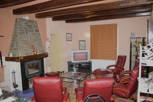 a living room with red chairs and a fireplace at Logîte Touristique Les 3 Loups in Châtenois
